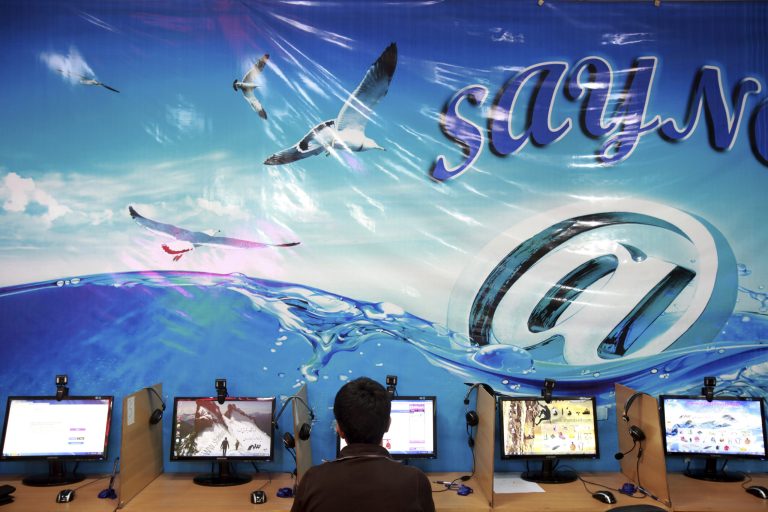 FILE - In this Tuesday, Sept, 17, 2013 file photo, an Iranian man surfs the Internet at a cafe in Tehran, Iran. Iran's official news agency reported on Sunday, July 13, 2014 that eight Facebook page administrators have been handed jail sentences from eight to 21 years. The report by IRNA says the defendants were convicted of plotting against national security, spreading propaganda against the ruling system and insulting officials. It did not identify the defendants or the Facebook pages. (AP Photo/Ebrahim Noroozi, File)