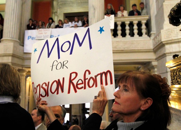 A protester, who refuesed to be identified, displays a placard calling for pension reform during a rally at the Statehouse, in Providence, R.I. (AP Photo/Steven Senne)