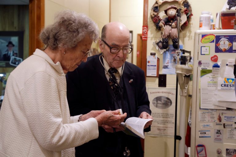 In this Tuesday, Oct. 30, 2012 photo, Dr. Russell Dohner, right, talks with nurse Rose Busby about a patient's prescription in Rushville, Ill. (AP Photo/Jeff Roberson)