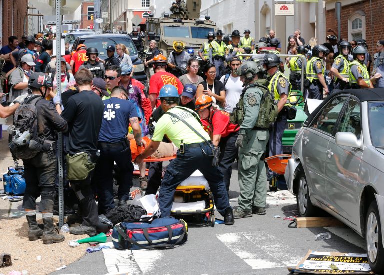 Rescue personnel help injured people after a car ran into a large group of protesters after an white nationalist rally in Charlottesville, Va., Saturday, Aug. 12, 2017. The nationalists were holding the rally to protest plans by the city of Charlottesville to remove a statue of Confederate Gen. Robert E. Lee. There were several hundred protesters marching in a long line when the car drove into a group of them. (AP Photo/Steve Helber)