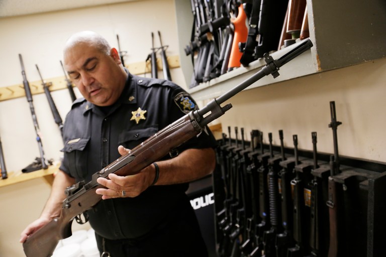 Macomb County Sheriff Sgt. Phil Abdoo shows an M14 rifle acquired through a federal government program at the range at the Macomb County Sheriff's department in Mt. Clemens, Mich., Thursday, July 17, 2014. (AP Photo/Detroit Free Press, Mandi Wright)