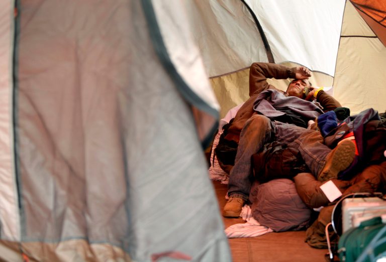   FILE - In this file photo of Nov. 20, 2012 photo, Anthony Gatti makes a call while resting in a tent where he is living in the Midland Beach section of the Staten Island borough of New York. The image of his brother trapped in a car with water rising to his neck, his eyes silently pleading for help, is part of a recurring nightmare that wakes Anthony Gatti up, screaming, at night. Gatti hauled his brother out of the car just in time, saving his life at the height of Superstorm Sandy. The two men rode out the hurricane in their childhood home and survived. But weeks afterward, Gatti still hasnât moved on. Heâs still living in a tent in the backyard, burning pieces of furniture as firewood, refusing to leave the site of his home until the place is demolished. (AP Photo/Seth Wenig, File)  