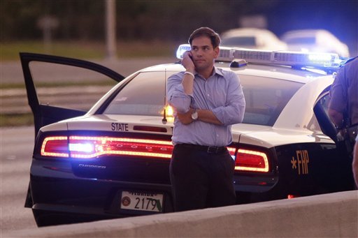 Sen. Marco Rubio, R-Fla., who is traveling with Republican presidential candidate and former Massachusetts Gov. Mitt Romney, uses a phone as he stands alongside Interstate 4 in Lakewood Crest, Fla., Saturday, Oct. 27, 2012 after the motorcade was stopped. The 12-year-old daughter of Sen. Rubio had been airlifted to a hospital after a Saturday motor vehicle accident. A Rubio spokesman reports that the girl is in stable condition. (AP Photo/Charles Dharapak)