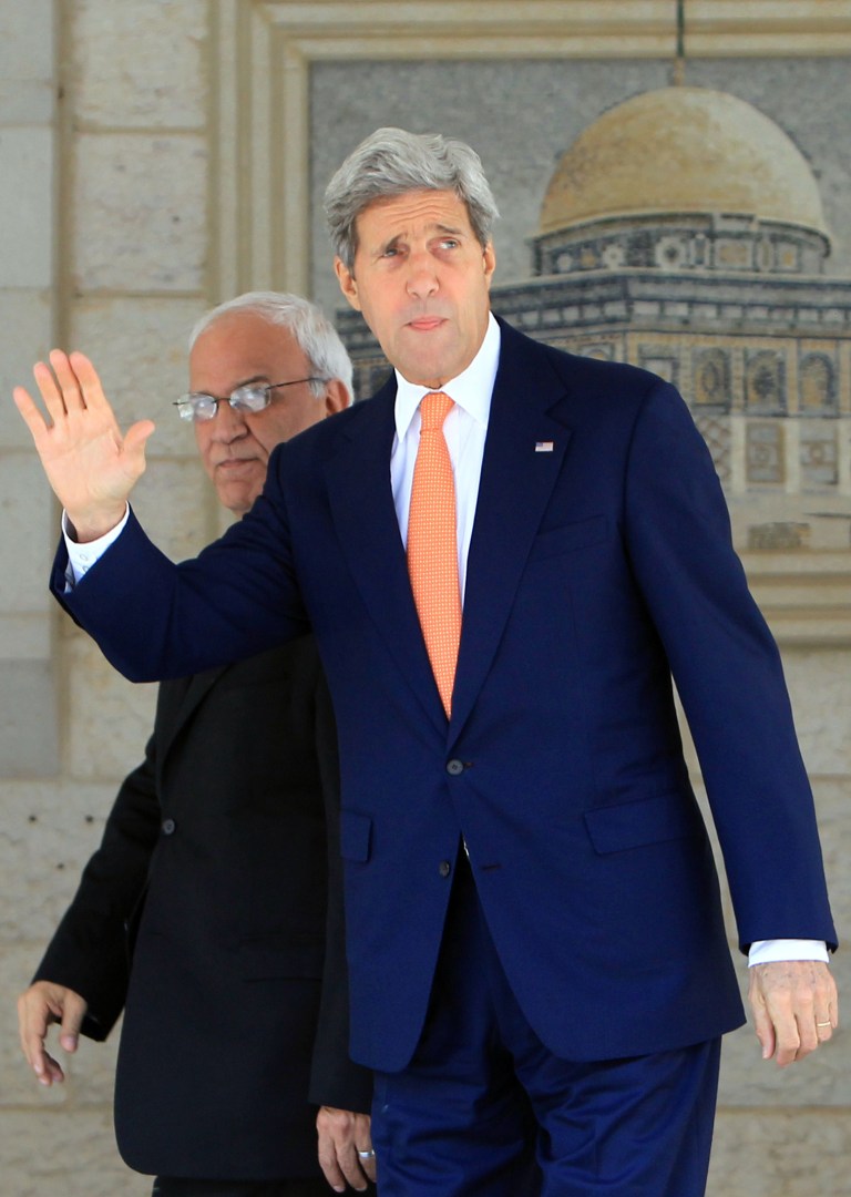 U.S. Secretary of State John Kerry, right, walking with chief Palestinian negotiator Saeb Erekat, waves upon his arrival at a meeting with Palestinian President Mahmoud Abbas in the West Bank city of Ramallah on Wednesday, July 23, 2014. Kerry is meeting with United Nations Secretary-General Ban Ki-moon, Israeli Prime Minister Benjamin Netanyahu and Abbas as efforts for a cease-fire between Hamas and Israel continues. (AP Photo/Abbas Momani, Pool)