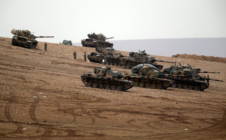 Turkish soldiers hold their positions with their tanks on a hilltop on the outskirts of Suruc, at the Turkey-Syria border, overlooking Kobani, Syria, during fighting between Syrian Kurds and the militants of Islamic State group, Sunday, Oct. 12, 2014. Kobani, also known as Ayn Arab, and its surrounding areas, has been under assault by extremists of the Islamic State group since mid-September and is being defended by Kurdish fighters.(AP Photo/Lefteris Pitarakis)