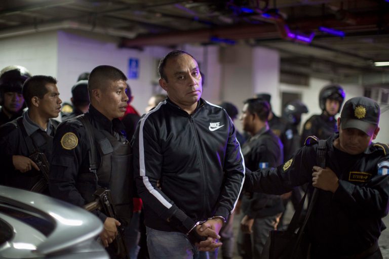 Former Guatemalan Army Captain Byron Lima Oliva, center, sentenced in 2006 to 20 years in jail for the 1998 slaying of Bishop Juan Jose Gerardi, is escorted by police agents as he arrives to a courtroom in Guatemala City, Wednesday, Sept. 3, 2014. Prosecutors said that Lima built an illicit business empire in prison by extorting money from other inmates in return for favors like allowing prohibited cellphones, and has been charged with money laundering and organized crime. (AP Photo/Luis Soto)