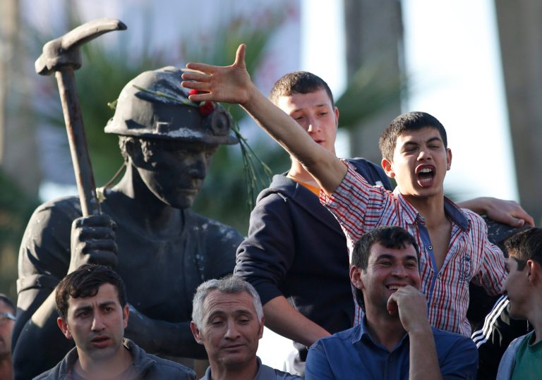 Anti-government protesters chant slogans on a monument for the town's miners, during a march in Soma, Turkey where the mine accident took place, Friday, May 16, 2014. Hundreds of protesters took part in the march against the government and there were clashes with the police forces. An explosion and fire at a coal mine in Soma, some 250 kilometers (155 miles) south of Istanbul, killed hundreds of workers, authorities said, in one of the worst mining disasters in Turkish history. (AP Photo/Lefteris Pitarakis)