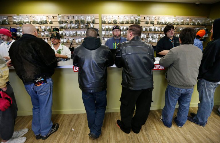 Employees help customers at the crowded sales counter inside the Medicine Man marijuana retail store, in Denver. (AP/Brennan Linsley)
