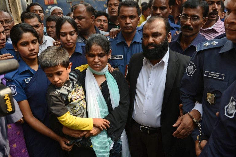 Two owners of Tazreen Fashions Ltd., Delwar Hossain, center left, and his wife, Mahmuda Akter, right, are escorted by security personnel to a court in Dhaka, Bangladesh, Sunday, Feb. 9, 2014. The owners of a Bangladesh garment factory where 112 workers died in a fire two years ago surrendered on Sunday and sought bail after they were charged with homicide. (AP Photo)