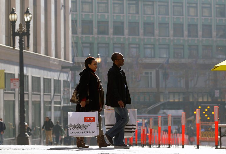 A man and woman carry shopping bags as they cross the street in San Francisco. (AP/Jeff Chiu)