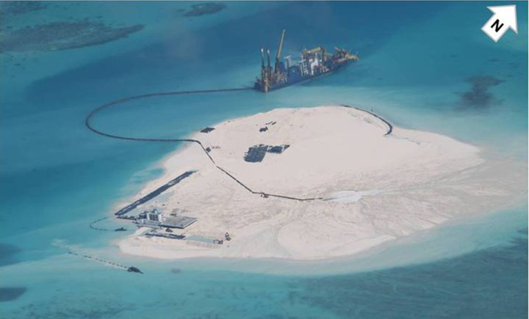 In this photo taken Feb. 25, 2014 by surveillance planes and released Thursday, May 15, 2014, by the Philippine Department of Foreign Affairs, a Chinese vessel, top center, is used to expand structures and land on the Johnson Reef, called Mabini by the Philippines and Chigua by China, at the Spratly Islands at South China Sea, Philippines. The Philippines has protested China's reclamation of land in the disputed reef in the South China Sea that can be used to build an airstrip or an offshore military base in the increasingly volatile region, the country's top diplomat and other officials said Wednesday, May 14, 2014.  The white arrow was added by the source. (AP Photo/Philippine Department of Foreign Affairs)