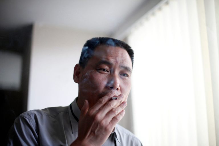 FILE - In this June 1, 2009 file photo, human rights lawyer Pu Zhiqiang, right, smokes a cigarette, at his office in Beijing. According to other Chinese activists on Tuesday, May 6, 2014, Chinese authorities have detained Pu in an apparent bid to deter activists from marking the upcoming 25th anniversary of a brutal military suppression of pro-democracy protesters. (AP Photo/Elizabeth Dalziel, File)