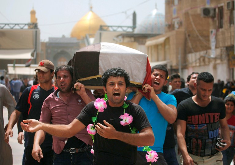 Friends of Mustafa Mounir, 19, chant slogans against the al-Qaida breakaway group Islamic State of Iraq and the Levant (ISIL), while carrying his flag-draped coffin during his funeral procession in Najaf, 100 miles (160 kilometers) south of Baghdad, Iraq, Friday, April 18, 2014. Mustafa Mounir was killed in a car bomb attack in Baghdad on Thursday, his family said. (AP Photo/Jaber al-Helo)