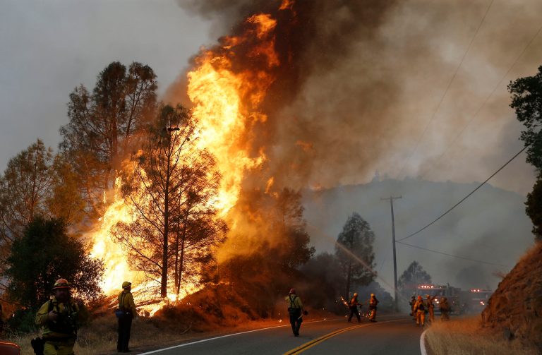 Firefighters spray a hose at a fire along Morgan Valley Road near Lower Lake, Calif., Friday, July 31, 2015. A series of wildfires were intensified by dry vegetation, triple-digit temperatures and gusting winds. (AP Photo/Jeff Chiu)