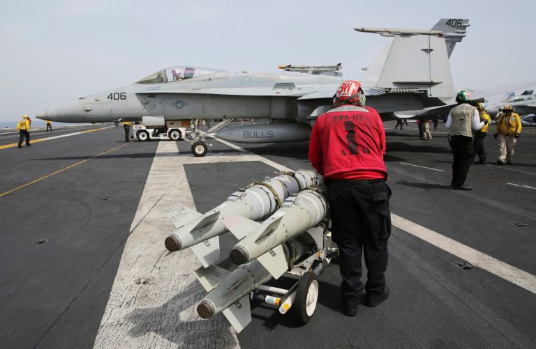 A sailor moves missiles across the flight deck of the USS George H.W. Bush as it travels through the Persian Gulf on March 22. The carrier will begin launching airstrikes targeting the Islamic State group in Iraq and Syria. (AP Photo/Jon Gambrell)