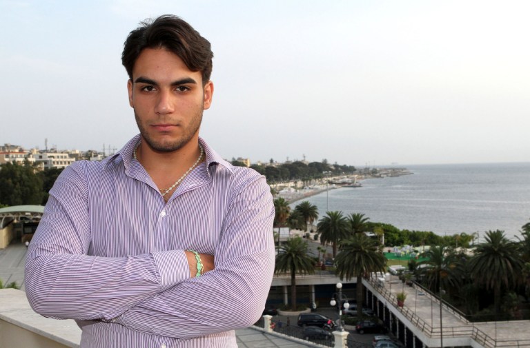 In this June 26, 2014 photo, Riccardo Cordi' stands on a terrace in Reggio Calabria, Sicily, Italy with the Strait of Messina in the background. Cordi' was exiled to Messina during a pioneering anti-mafia program for juveniles, a kind of rehab away from the mob. (AP Photo/Adriana Sapone)