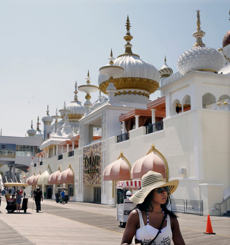 In this Wednesday, July 23, 2014 file photo, people walk on The Boardwalk past Trump Taj Mahal Casino Resort in Atlantic City, N.J. A Delaware bankruptcy judge on Wednesday, Sept. 10, 2014, agreed to allow Trump Entertainment Resorts to temporarily continue operations using cash owed to billionaire Carl Icahn, the company's sole secured lender. Judge Kevin Gross also signed routine orders allowing the company, which owns two Atlantic City casinos, to continue paying vendors and employees as it works on a debt restructuring that could avert the closing of the Taj Mahal Casino Resort. The company, whose Trump Plaza resort is closing in a week, sought bankruptcy protection on Tuesday. (AP Photo/Mel Evans, File)