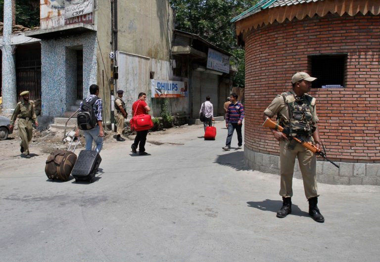   Indian paramilitary soldiers stand guard as Indian tourists walk with their baggage during a strike in Srinagar, India, Monday, June 11, 2012. Schools and some shops were shut in Kashmir's main city of Srinagar in a strike called to honor people killed in 2010 protesting Indian rule over the Himalayan territory. A lack of public transport prevented government employees from getting to work Monday. (AP Photo/Mukhtar Khan)  