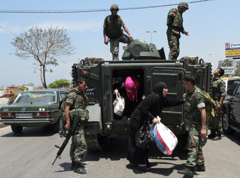Lebanese army soldiers help women to be taken out of the Bab Tabbaneh district of Tripoli to safer areas, in the northern port city of Tripoli, Lebanon, Thursday, May. 23, 2013. Opponents and supporters of Syrian President Bashar Assad traded heavy machine gun fire and mortar shells in the Lebanese port city of Tripoli, leaving five people dead in what was described as some of the heaviest fighting there in years, officials said Thursday. (AP Photo)