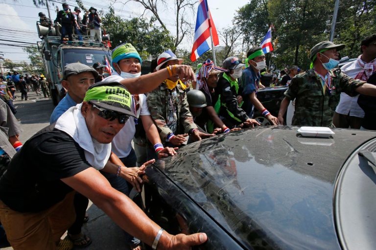 Anti-government protesters aimed at disrupting government offices, push back a police vehicle blocking the entrance to the Department of Forestry, Wednesday, Feb. 12, 2014, in Bangkok, Thailand. Thailand's Constitutional Court has rejected petitions brought by both the government and main opposition party accusing each other of attempting to overthrow the country's system of government during recent elections. (AP Photo/Wally Santana)