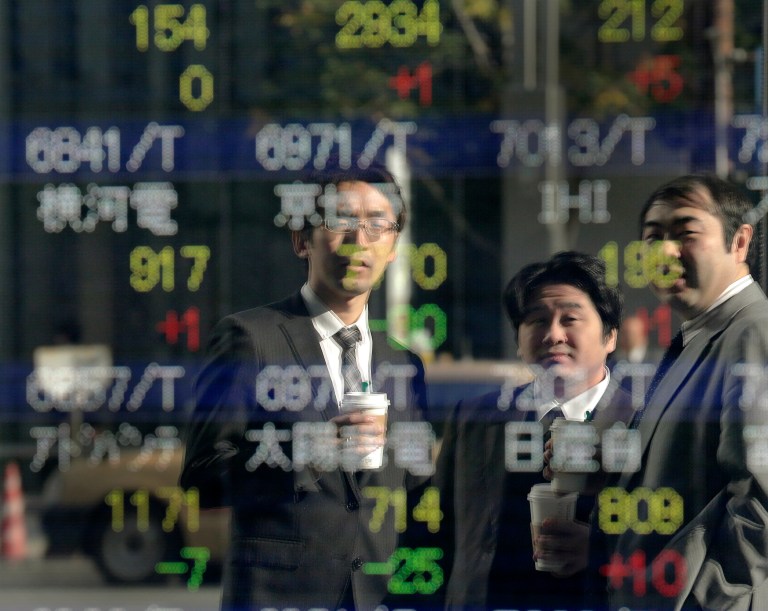   Men look at the electronic stock board of a securities firm in Tokyo, Tuesday, Dec. 18, 2012. Asian stock markets were mostly higher Tuesday, boosted by signs China's recovery is gaining traction and hopes for a new stimulus in Japan. (AP Photo/Itsuo Inouye)  