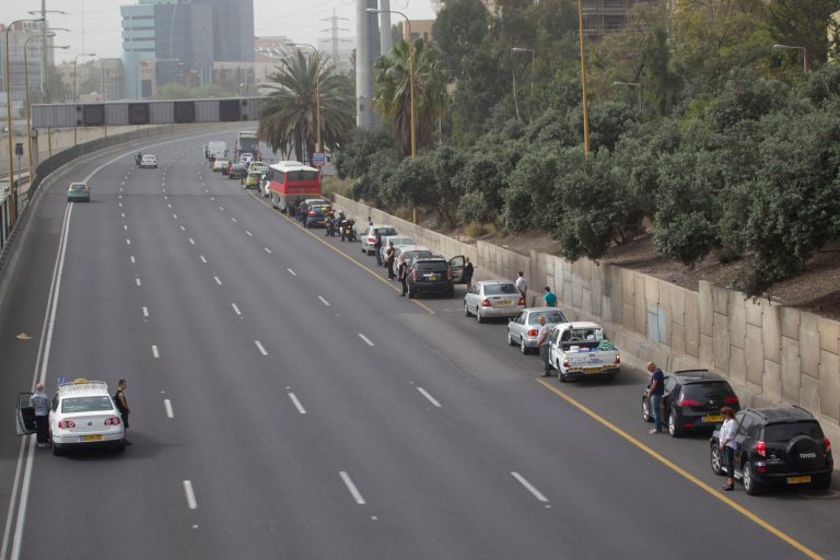 Israeli motorists stand still next to their cars on a freeway as a two-minute siren sounds in memory of victims of the Holocaust in Tel Aviv, Israel, Monday, April 8, 2013. Holocaust remembrance day is one of the most solemn on Israel's calendar with restaurants and places of entertainment shut down, and radio and TV programming focused on Holocaust documentaries and interviews with survivors. (AP Photo/Ariel Schalit)