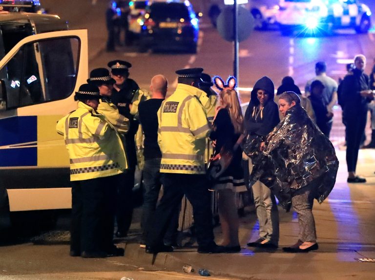 Emergency services personnel speak to people outside Manchester Arena after reports of an explosion at the venue during an Ariana Grande concert in Manchester, England, Monday. Several people have died following an explosion Monday night at an Ariana Grande concert in northern England, police and witnesses said. The singer was not injured, according to a representative. (Peter Byrne/PA via AP)