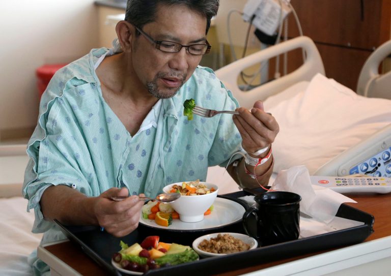 Heart patient Nhan Luong eats a heart healthy lunch of chicken fried rice, vegetables, fruit and dessert  Thursday, May 1, 2014, at Houston's Memorial Hermann Southwest Hospital. Menu changes are one way to care for an increasingly diverse population that hails from regions once not typical to the Houston area. (AP Photo/Pat Sullivan)