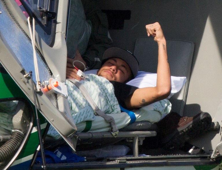 Brazil's Neymar lies inside a medical helicopter at the Granja Comary training center, in Teresopolis, Brazil, Saturday, July 5, 2014. Neymar was airlifted from Brazil's training camp Saturday and will be treated at home for his back injury. Neymar, the biggest football star in Brazil, was ruled out of the rest of the World Cup after fracturing his third vertebra during Friday's 2-1 quarterfinal win over Colombia. (AP Photo/Leo Correa)
