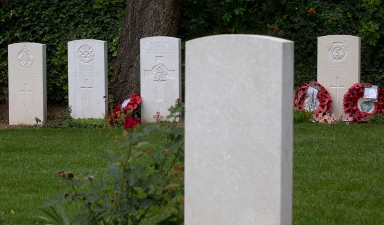 In this photo taken on Saturday, July 26, 2014, the graves of World War I soldiers, Private George Ellison, background right, and Private John Parr, foreground, face each other at the Saint Symphorien Cemetery near Mons, Belgium. Parr and Ellison were the first and the last, respectively, Commonwealth soldiers to die in battle during World War I. Purely by coincidence the graves are separated only by a few feet. (AP Photo/Virginia Mayo)