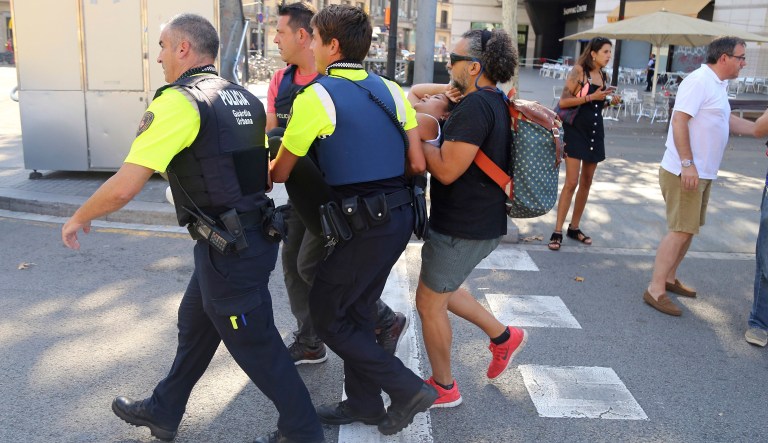 An injured person is carried in Barcelona, Spain, Thursday, Aug. 17, 2017 after a white van jumped the sidewalk in the historic Las Ramblas district, crashing into a summer crowd of residents and tourists and injuring several people, police said. (AP Photo/Oriol Duran)