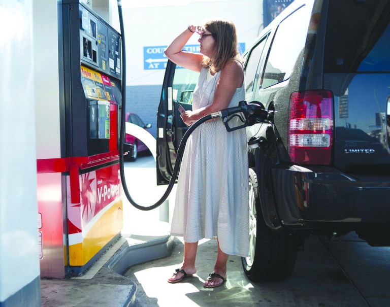 Teresa Jones watches the pump as she puts gas into her car at a Shell station on Pico Blvd in Los Angeles, Friday, Aug. 10, 2012. (AP Photo/Grant Hindsley)