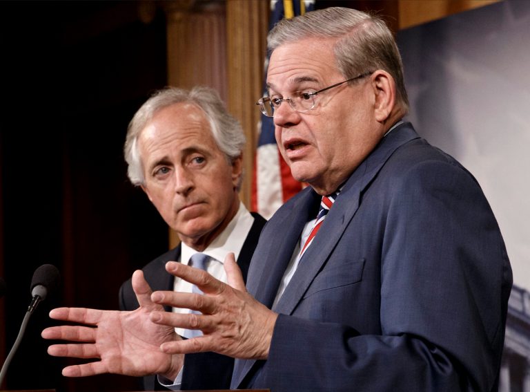 Senate Foreign Relations Committee Chairman Sen. Robert Menendez, D-N.J., accompanied by the committee's ranking member, Sen. Bob Corker, R-Tenn., gestures during a news conference on Capitol Hill in Washington, Thursday, March 27, 2014. (AP Photo/J. Scott Applewhite)