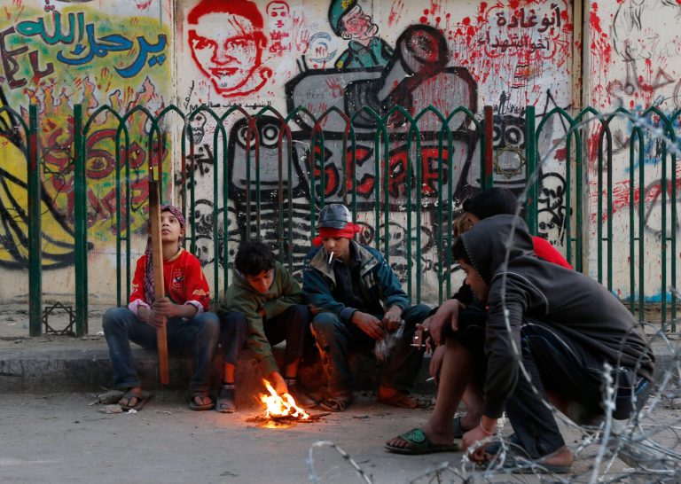   Egyptian boys sit by a fire near Tahrir Square in Cairo, Egypt, Monday, Dec. 17, 2012. Egypt's political crisis shows no signs of abating as the opposition to the country's Islamist government levels new challenges against the legitimacy of a referendum on a draft constitution. Morsi also confronts criticism from the judiciary, as prosecutors hold a sit-in to demand removal of a new prosecutor general he appointed. (AP Photo/Petr David Josek)  