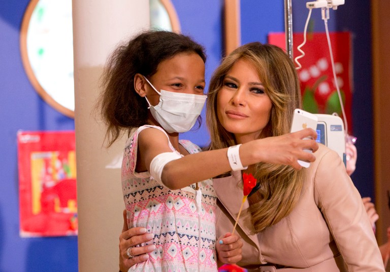 A small child takes a selfie with Melania Trump at the Queen Fabiola Childrens Hospital in Brussels on Thursday. Melania Trump visited children in a ward at the hospital on Thursday and participated in a crepe paper flower making workshop. (AP Photo/Virginia Mayo)