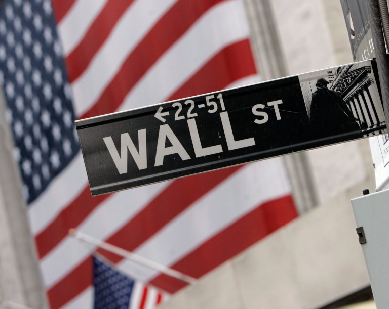 FILE - In this Aug. 16, 2007, file photo, the flags on the facade of the New York Stock Exchange provide a backdrop for a Wall Street street sign. Global stock markets were mostly lower Tuesday, Sept. 16, 2014, as jittery investors played it safe ahead of a potentially pivotal Federal Reserve meeting and the referendum on Scotland's independence on Thursday. (AP Photo/Richard Drew, File)