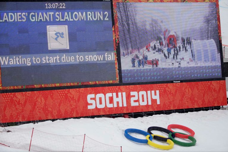A large screen announces a brief snow delay in the start of the second run of the women's giant slalom at the Sochi 2014 Winter Olympics, Tuesday, Feb. 18, 2014, in Krasnaya Polyana, Russia. (AP Photo/Gero Breloer)
