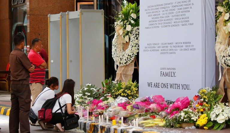 Employees of Resorts World Manila Casino and shopping mall pray at a memorial for the victims of the deadly attack by a lone gunman Sunday, June 4, 2017 in suburban Pasay city, southeast of Manila, Philippines. The lone suspect behind the deadly attack in Manila was a heavily indebted Filipino gambling addict, police said Sunday, bolstering their claim the assault was not terrorism-related. (AP Photo/Bullit Marquez)