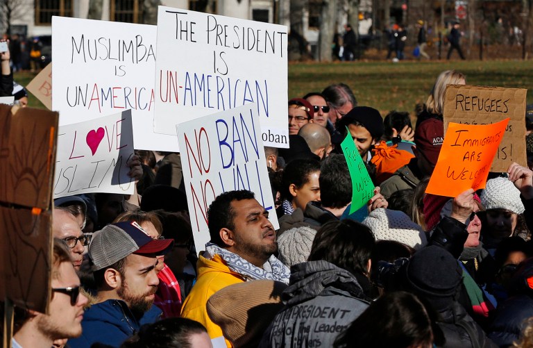 Protesters at an immigrants' rights rally hold signs while listening to speakers Sunday, Jan. 29, 2017, in Battery Park in New York. (AP Photo/Kathy Willens)