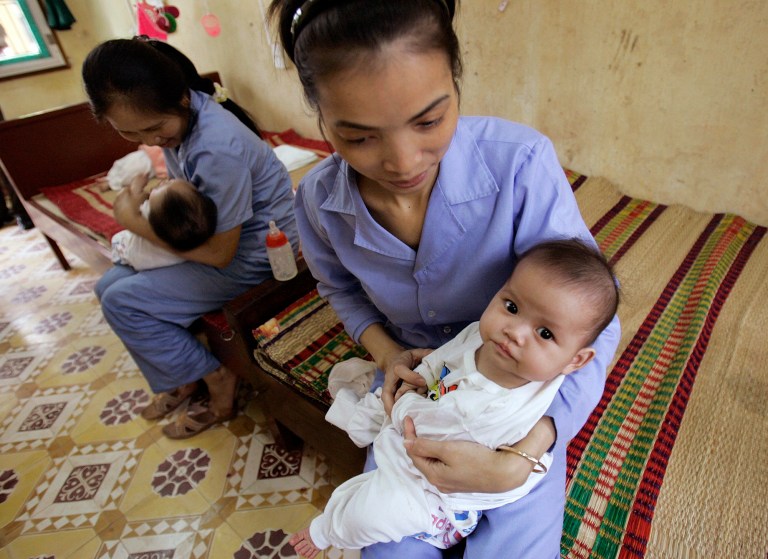 FILE - In this April 23, 2008 file photo, five-month-old baby girls are cradled by workers at an orphanage in Bac Ninh province, near Hanoi, Vietnam. Vietnam and the United States will soon resume limited inter-country adoptions, both nations said Friday, Sept. 12, 2014, six years after a ban was imposed because of allegations of widespread baby-selling and children offered without the consent of their birth parents. (AP Photo/Chitose Suzuki, File)