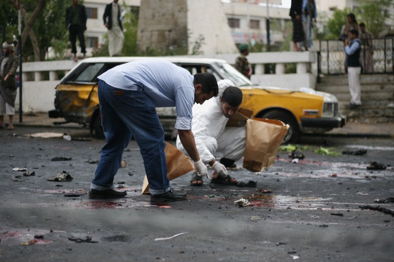 Yemeni security officials collect debris at the site of a suicide bombing in Sanaa, Yemen, Thursday, Oct. 9, 2014. A suicide bomber struck at the center of the Yemeni capital of Sanaa on Thursday, setting off his explosives at a gathering of supporters of the rebel Shiite Houthis who recently overran the city, security officials said. (AP Photo)