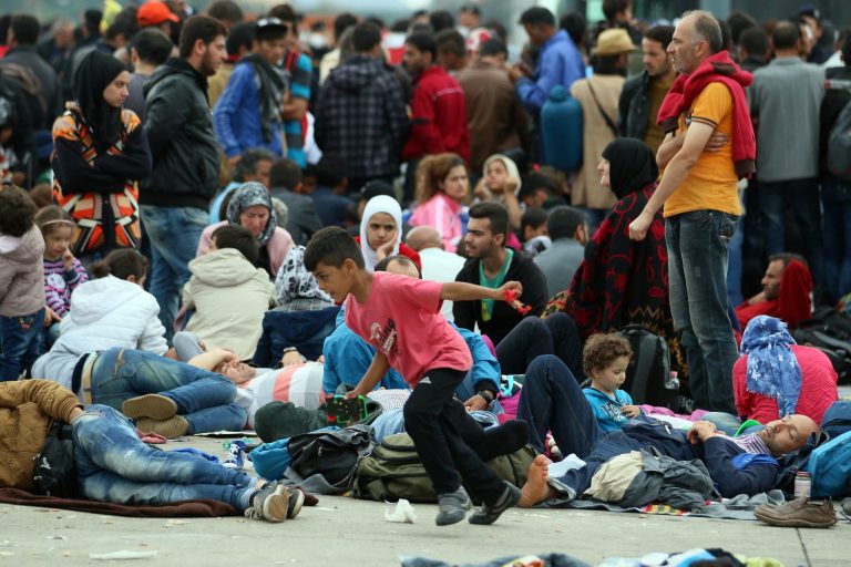 Refugees rest after crossing the border between Hungary and Austria in Nickelsdorf, Monday, Sept. 14, 2015. (AP Photo/Ronald Zak)