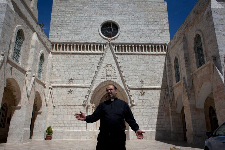 In this photo taken Sunday, May 18, 2014, Father Ibrahim Shomali, the parish priest of Beit Jala and leads meditating efforts between local Christians and Palestinian Christian emigre families who abandoned their homes, in order to keep Christian properties among Christians, stands at the Annunciation Latin Church, in the West Bank town of Beit Jala. Pope Francis will be arriving this weekend to the land where Christianity was born, and where Christians are disappearing. The Christian community in the Holy Land is one of the oldest in the world. But it has dwindled to around 2 percent of the population today, as economic hardship, violence and the bitter realities of the Israeli-Palestinian conflict have sent them searching for better opportunities overseas. (AP Photo/Nasser Nasser)