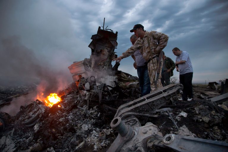 People inspect the crash site of a passenger plane near the village of Grabovo, Ukraine, Thursday, July 17, 2014. Ukraine said a passenger plane carrying 295 people was shot down Thursday as it flew over the country, and both the government and the pro-Russia separatists fighting in the region denied any responsibility for downing the plane. (AP Photo/Dmitry Lovetsky)