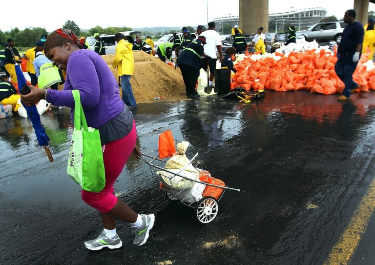 A woman hauls away sandbags after pickup at RFK stadium. Getty/Win McNamee