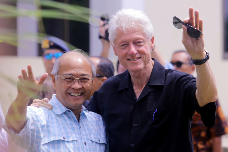 Former U.S. President Bill Clinton, right, and former head of the Rehabilitation and Reconstruction Agency for Aceh (BRR) Kuntoro Mangkusubroto wave at reporters during their visit to a tsunami evacuation facility in Banda Aceh, Indonesia, Saturday, July 19, 2014. Clinton is on a one-day visit to inspect the progress of the development of the the region almost a decade after it was devastated by Indian Ocean tsunami. (AP Photo/Heri Juanda)