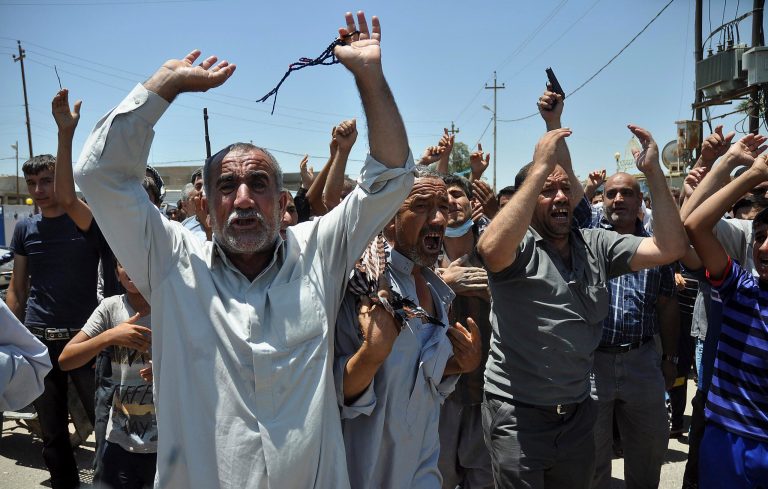 In this June 23, 2014, photo, mourners chant slogans against the al-Qaida breakaway group Islamic State of Iraq and the Levant after they bury 15 bodies in the village of Taza Khormato near the northern oil-rich city of Kirkuk, Iraq. U.S. teams of special forces going into Iraq after a three-year gap will face an aggressive insurgency, a splintering military and a precarious political situation as they help Iraqi security forces improve their ability to battle Sunni militants. (AP Photo/Emad Matti)
