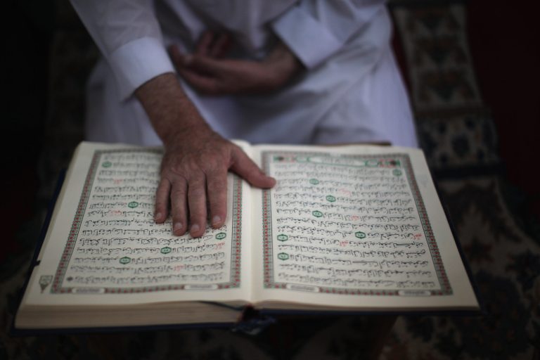 A mourner reads the Quran as he attends the funeral of Palestinian Saad al-Majdalali on August 17, 2011 in Gaza City, Gaza. (Photo by Christopher Furlong/Getty Images)