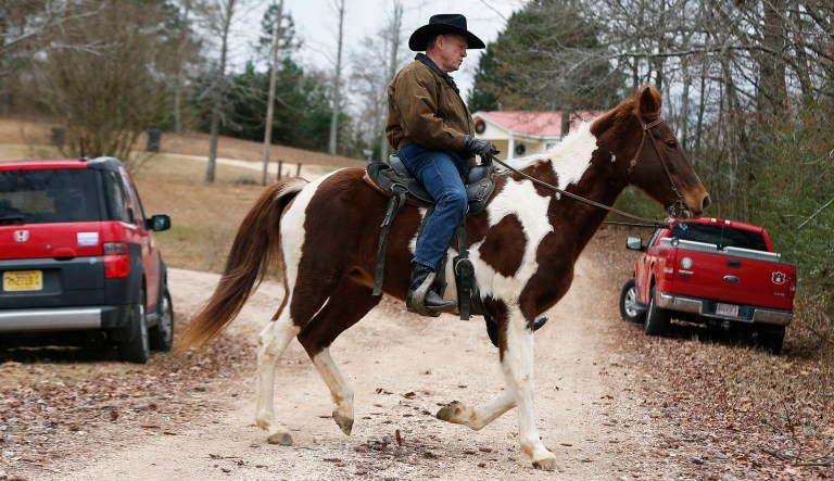 U.S. Senate Republican candidate Roy Moore rides a horse to vote, Tuesday, Dec. 12, 2017, in Gallant, Ala. Alabama voters are deciding between Moore, former chief justice of the Alabama Supreme Court and Democrat Doug Jones. (AP Photo/Brynn Anderson)