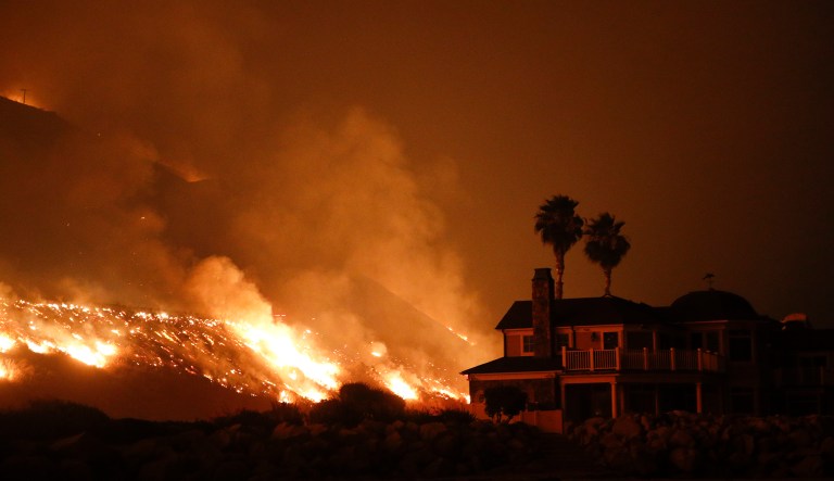 A wildfire threatens homes as it burns along the 101 Freeway Tuesday, Dec. 5, 2017, in Ventura, Calif. (AP Photo/Jae C. Hong)